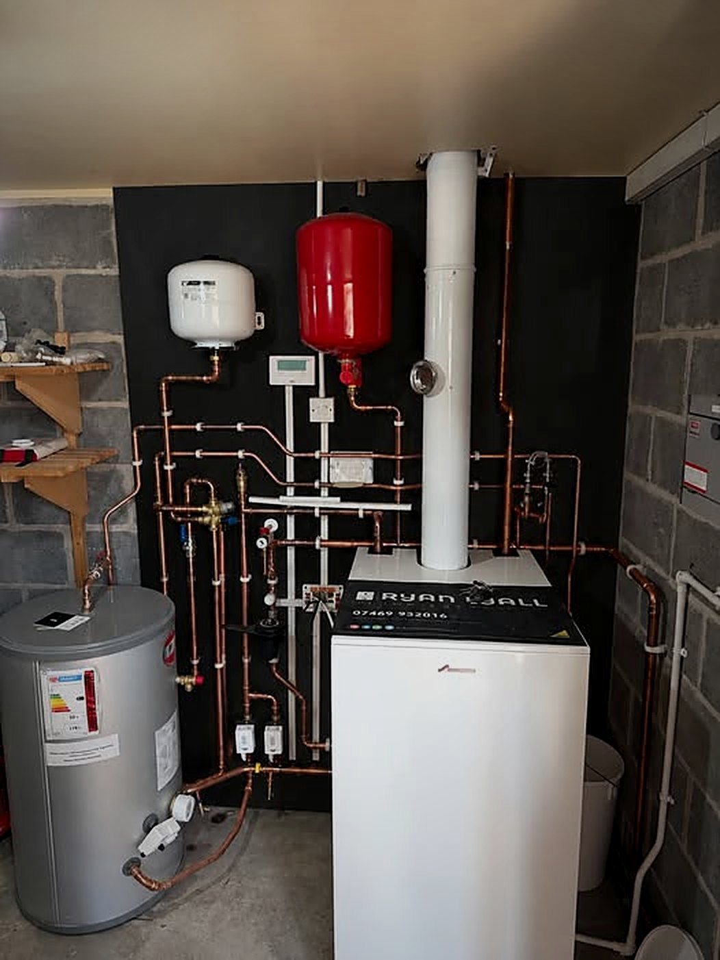 Oil boiler plant room with copper pipework, expansion vessels and a cylinder